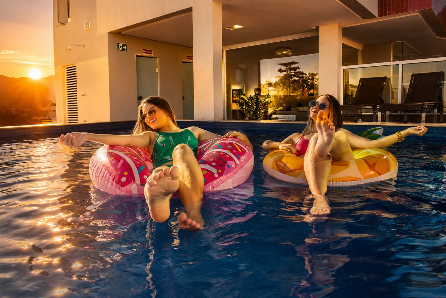 Hóspedes relaxando em boias na piscina do Serra Madre Hotel ao pôr do sol